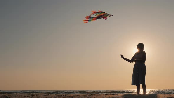 Side View  Silhouette of a Young Woman with a Kite