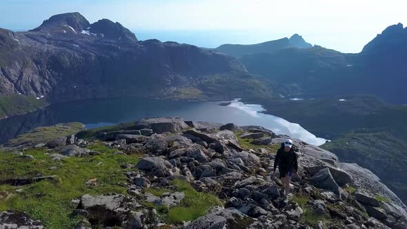 Aerial View of Girl with a Backpack Rises on a Mountain Ridge