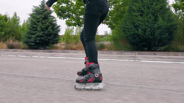 Follow Shot, Lateral View of Young Woman Practicing Roller Skating on Road.