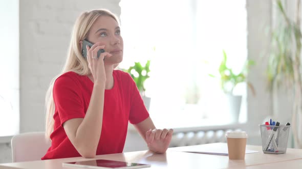 Young Blonde Woman Talking on Phone in Office