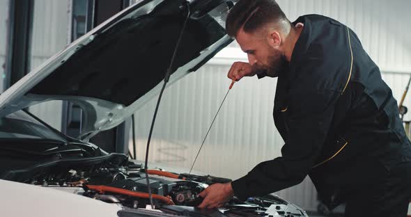 Good Looking Mechanic Guy in a Modern Service Auto