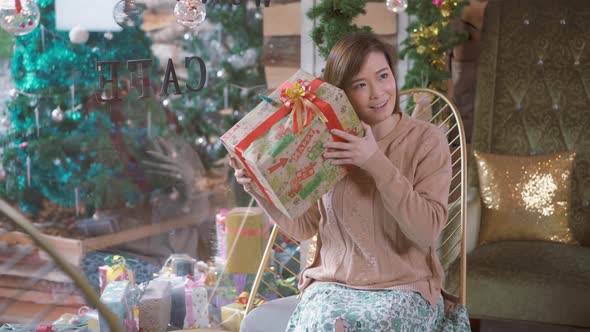 Cheerful young woman smiling and received a New Year gift in the restaurant.