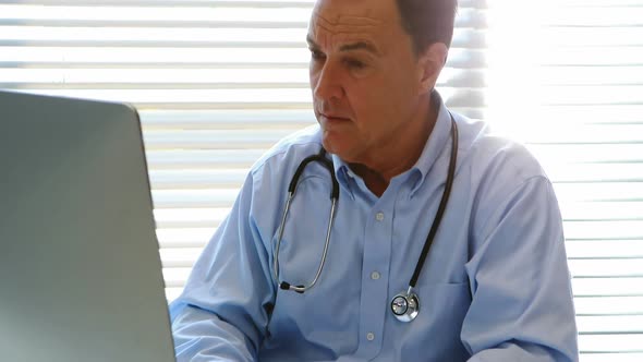 Male doctor working on personal computer