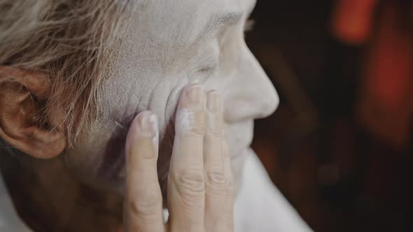 Wrinkled Clown Smears White Paint Over Face in Dressing Room