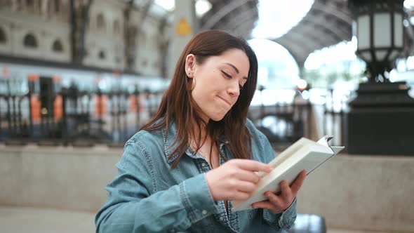 Laughing brunette woman tourist reading book