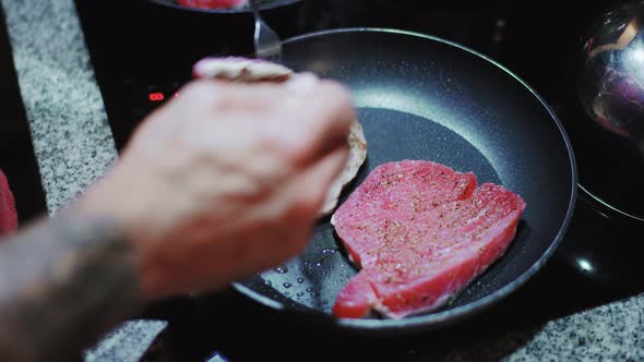 Cooking big tuna steaks with spices and herbs in pan for a keto dinner