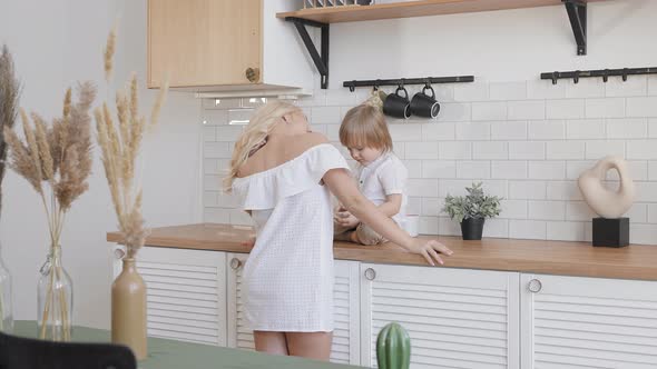 Blonde Woman with Her Son in the Kitchen