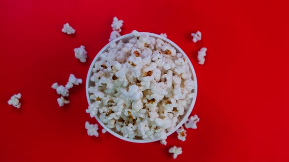 Rotating Bucketbox or Bowl with Popcorn on a Red Background the Concept of a Cinema Watching Movies