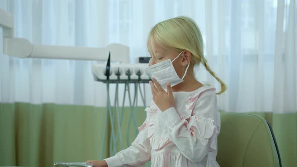 Little Girl in Raspiratory Mask Play with Nippers