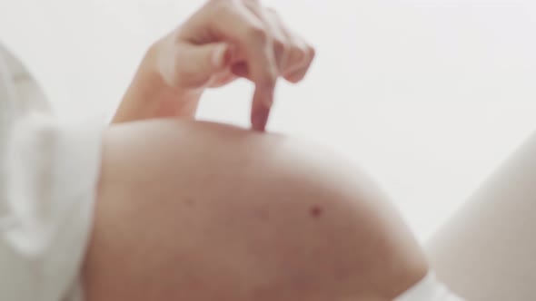 Pregnant woman touching her belly. Pregnancy, motherhood, and expectation concept.