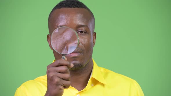 Young African Businessman Playing with Magnifying Glass