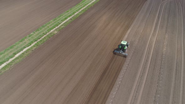 Tractor with Harrows on the Farmland