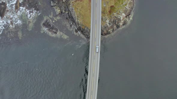 Aerial Drone Shot Following Car Driving On Famous Storseisund Bridge in Norway. - top down