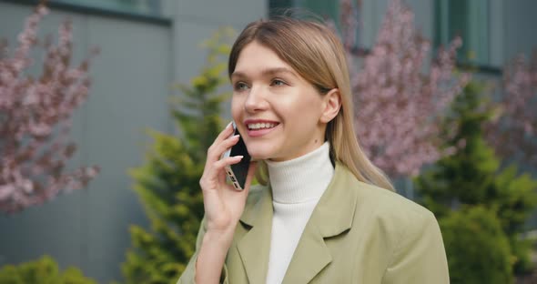 Modern Business Woman Standing Outdoors Friendly Talking on Mobile Phone.