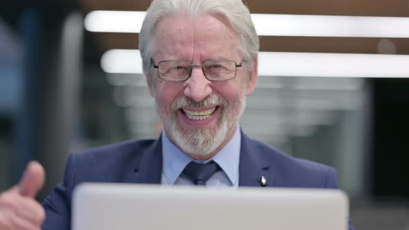 Close Up of Old Businessman with Laptop Showing Thumbs Up Sign