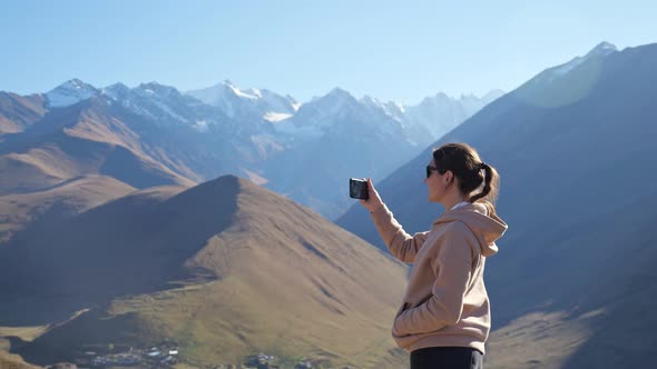 Amazed Woman Makes Video of High Mountain Peaks at Sunlight