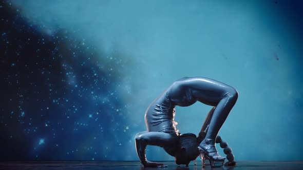 Flexible Woman Contortionist Performing on Stage Against Starry Space Back