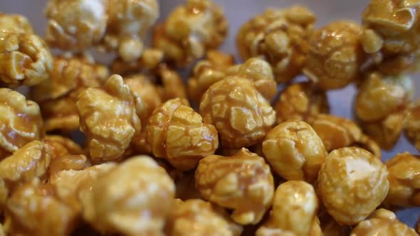 Macro detail closeup of fresh hot golden popcorn, handheld