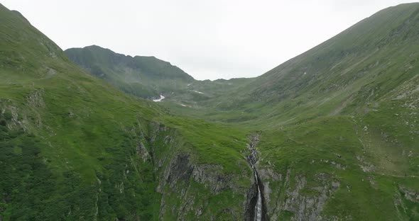 flying away from a valley in mountains with waterfall