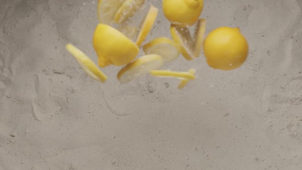 Whole Lemons with Cut Pieces of Lemon Fly and Collide and Fall on the Sand