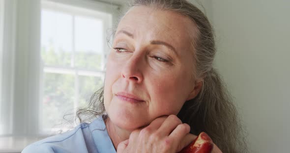 Senior caucasian woman wearing blue shirt and sitting with cane in living room