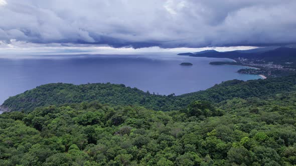 Stormy clouds dark clouds over sea at sunset or sunrise sky Mountain rainforest in the foreground