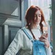 Young caucasian woman using a smartphone at the door step - VideoHive Item for Sale