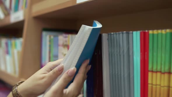 Woman is Checking Sheets of Notebook in a Office Supplies Department Closeup