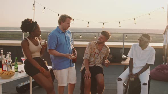 Young People Chatting on Rooftop Terrace on Summer Evening