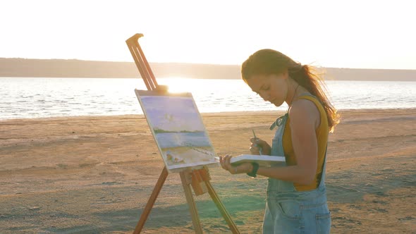 Young Woman Artist Painting Landscape in the Open Air on the Beach