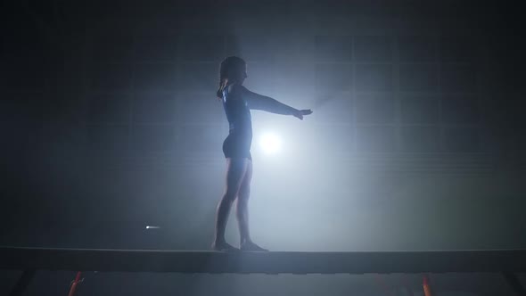 Teen Girl Gymnast is Performing Jump on Balance Beam Training in Sport School and Preparing