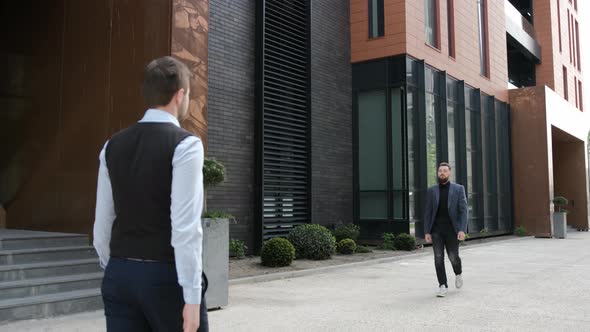 Businessmen Are Meeting Each Other Outside and Shake the Hands To Say Hello. Business Building