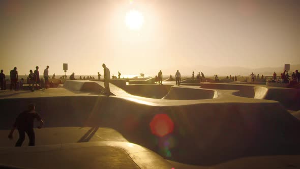 Slow motion lens flare shot of people at the skate park near Venice Beach, California