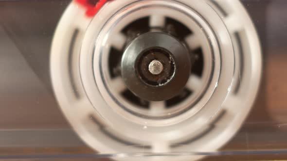 Close-up of a spinning reel of an audio cassette reproducing.