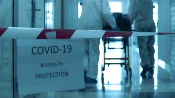 Doctors Are Taking a Patient Through a Quarantined Corridor. Coronavirus Concept.