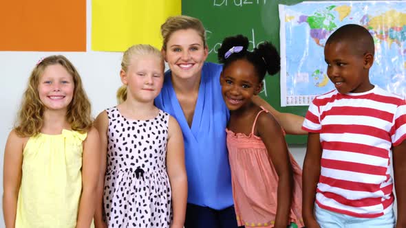 Portrait of teacher and kids smiling in classroom