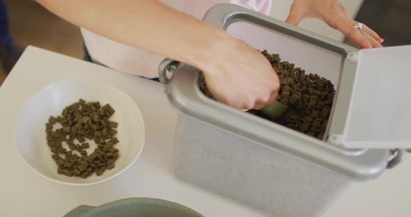 Caucasian woman preparing bowl with food for her dog