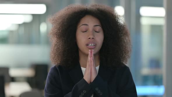 Portrait of Hopeful African Businesswoman Praying