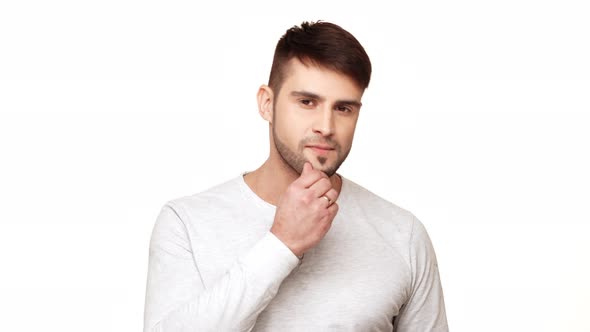 Confident Caucasian Male in Sweatshirt and Light Dark Bristle Touching His Chin and Pointing at