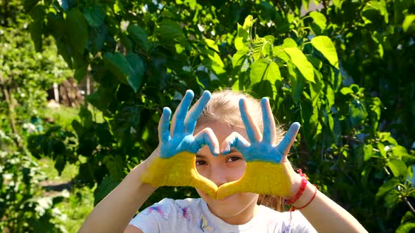 The Ukrainian Flag is Drawn on the Child Hands