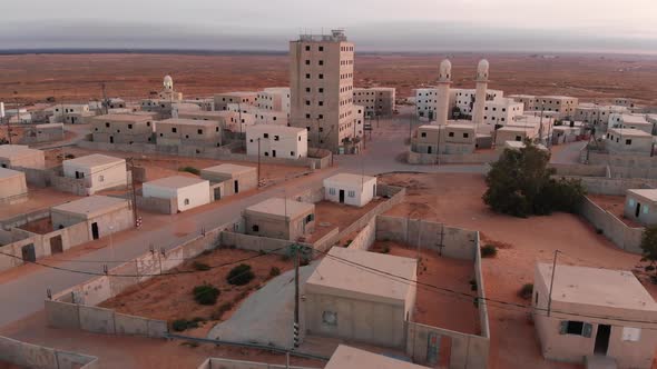 aerial shot of a big building in an old empty poor city in the desert in palestine near Gaza at morn