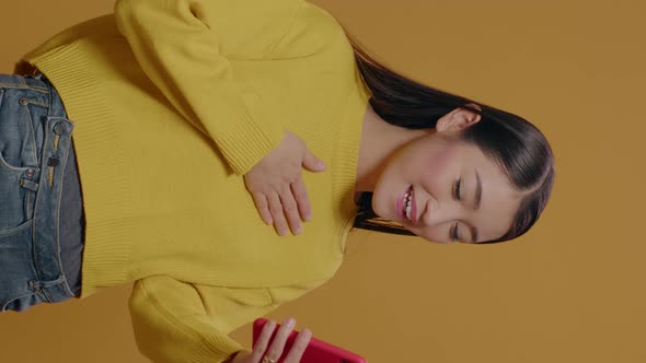 Vertical Video Cheerful Woman Waving at Video Call on Smartphone in Studio