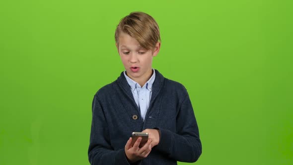 Child Thumbs the Photo on the Phone. Green Screen