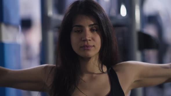 Closeup Front View of Focused Middle Eastern Woman Looking at Camera Training Hand Muscles in Seated