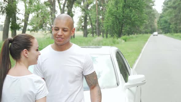 Happy Young Multiethnic Couple Laughing Resting From Driving During Road Trip