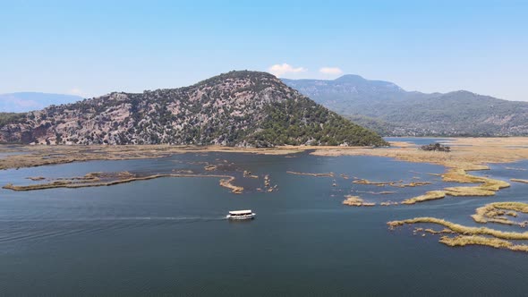 Filming from a drone of a pleasure boat against the background of a green mountain frame in Turkey,