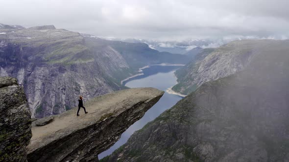 Hiker Walking On Rocky Outcrop Over River Valley