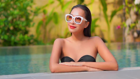 Young asian woman enjoy around outdoor swimming pool for leisure