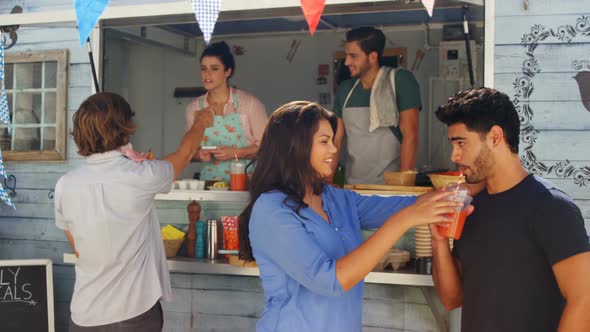 Man feeding juice to woman