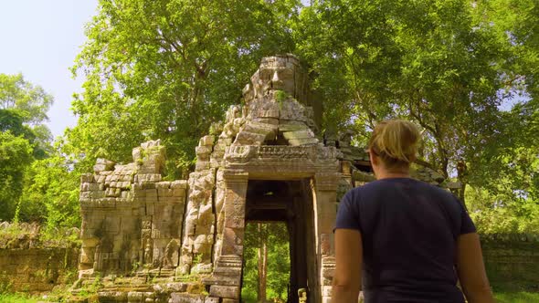 Tourist Woman Exploring Khmer Empire Tower Ruins in Cambodia